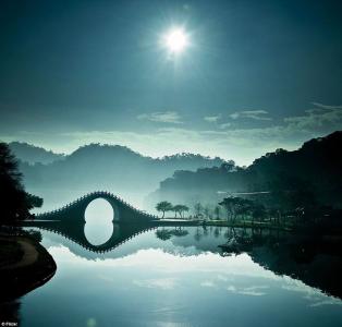 台湾太阳，天空中的云彩，丘陵，树木，河流，桥梁，其在水中的倒影