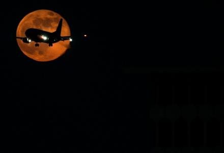 飞机临近，背景为月亮，背景为黑色