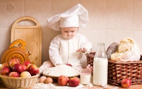 婴儿厨师，桌上的孩子，面粉中的小脸