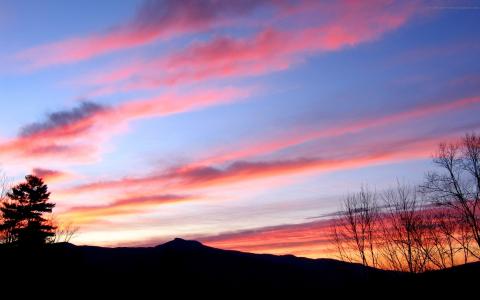 粉红色的夕阳，柔和的云彩，丘陵