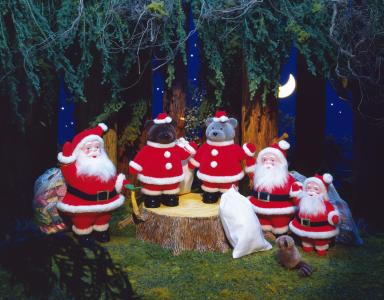 圣诞老人与一袋礼物背景下夜间森林，一只小动物，一只小熊在大麻上